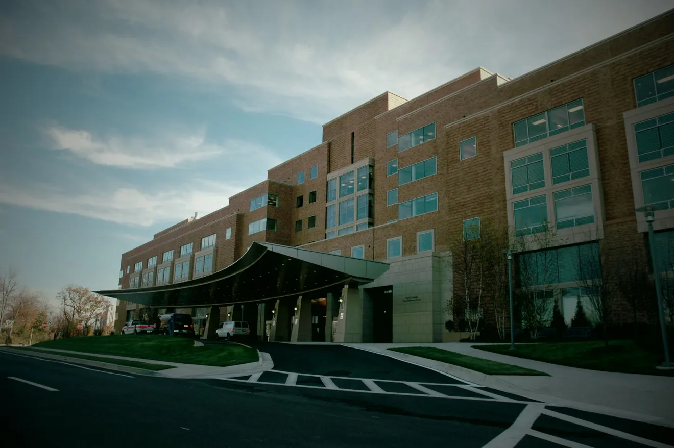 A modern medical building entrance with a covered, step-free walkway (illustrative stock photography)